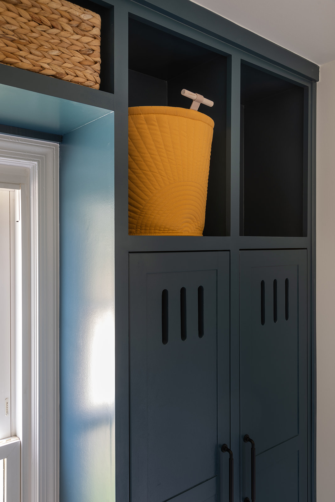A bright, organized mudroom with custom cubbies for backpacks and shoes, a perfect example of functional, family-friendly interior design.