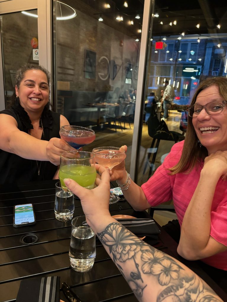 Paola, Christa, and Carly cheersing cocktails to celebrate a successful Spring 2024 High Point Market.